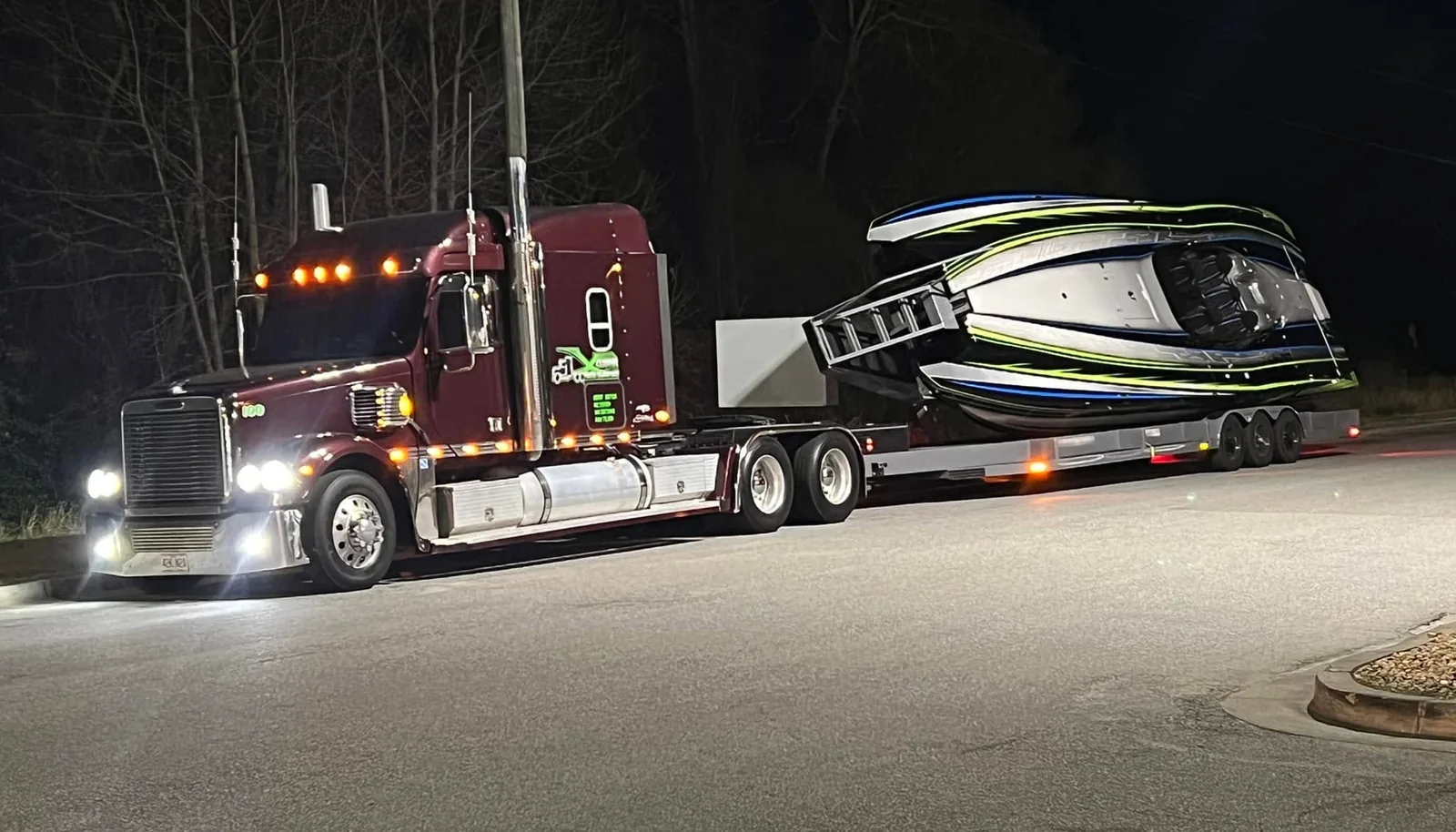 Xclusive Transport hauling a go fast boat on a lowboy trailer