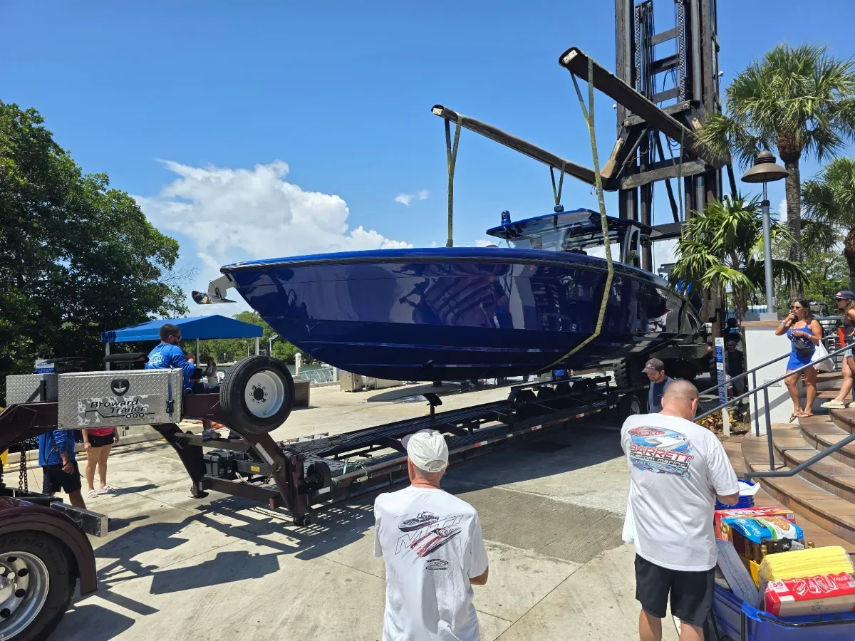 Boat being lifted onto the trailer at a marina for transport