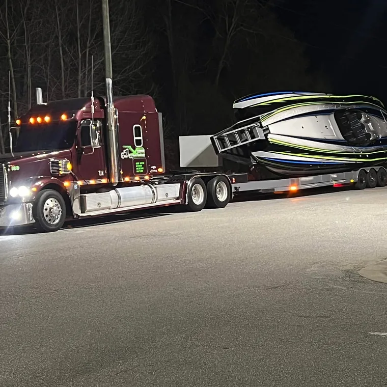 Xclusive Transport hauling a go fast boat on a dedicated lowboy trailer
