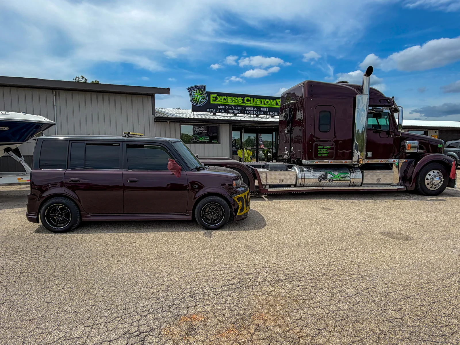 Xclusive Transport pilot car and Freightliner Coronado side by side in matching maroon paint