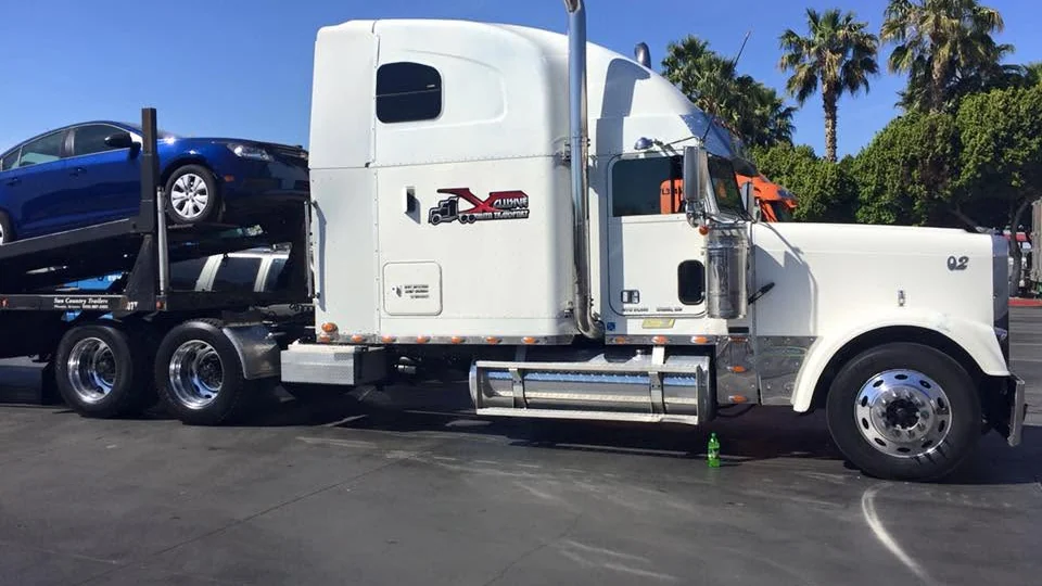 Customer vehicles loaded and strapped on an open car hauler